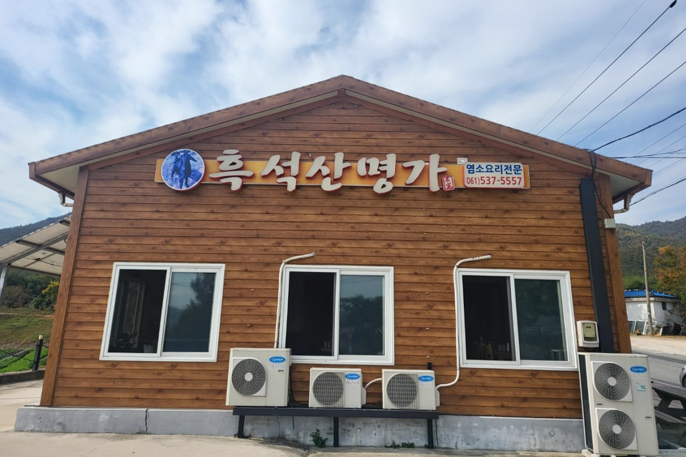 흑석산명가 간판과 창문이 있는 목조 본점 외관